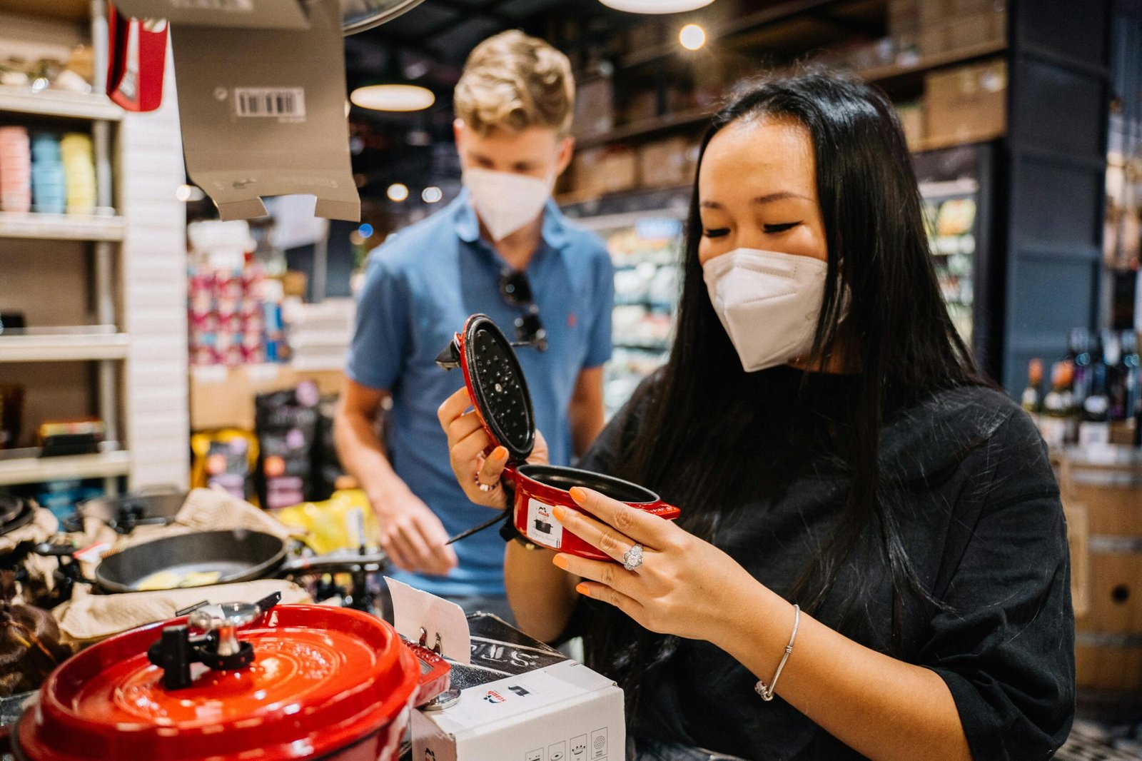 A couple wearing masks shops for kitchenware, exemplifying pandemic precautions.